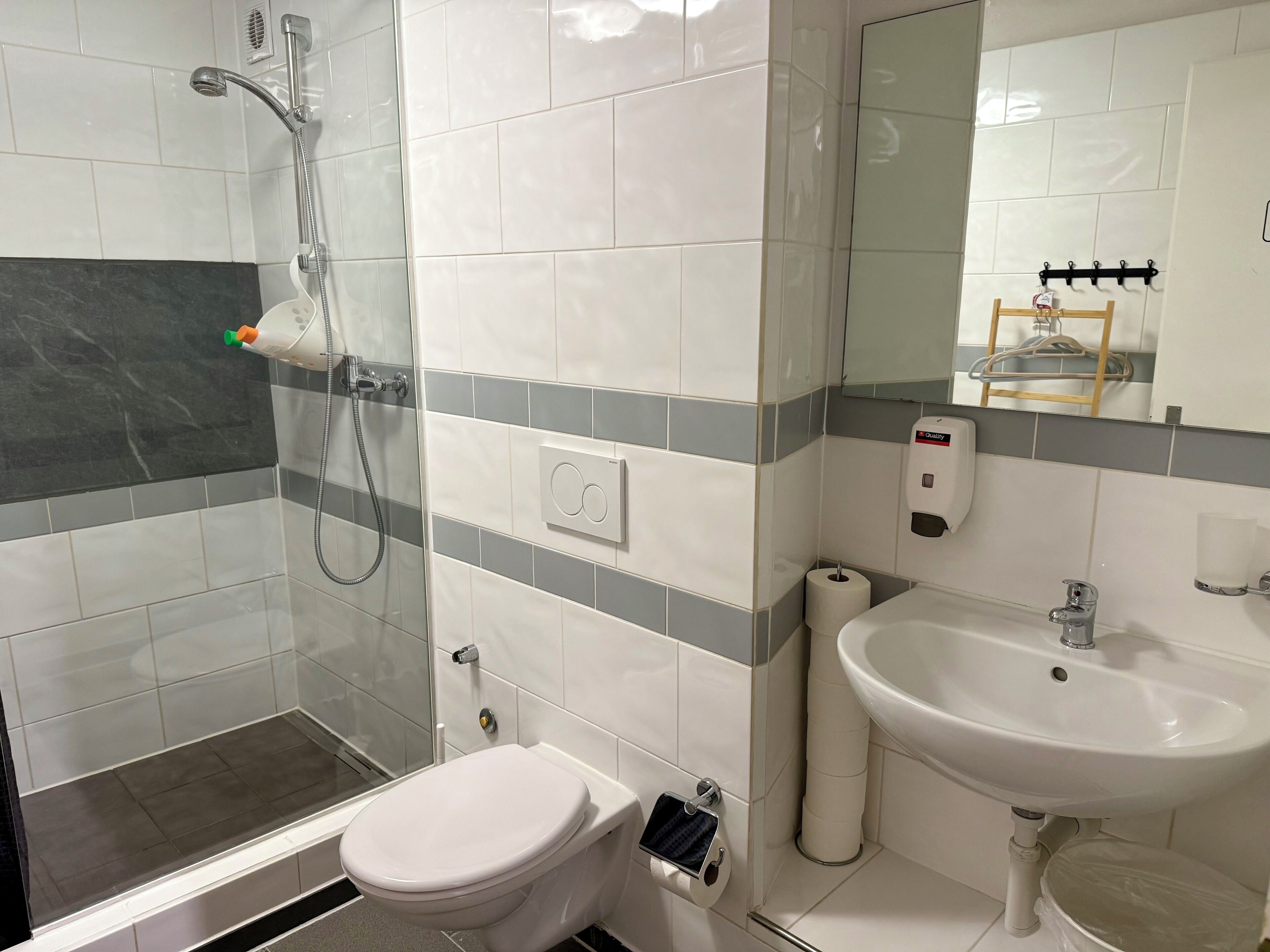 A bathroom with a shower, toilet, and sink.