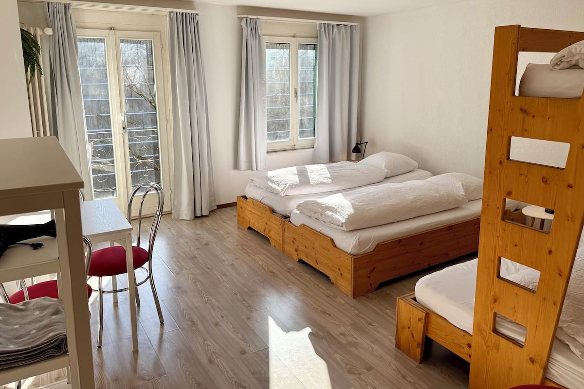 Una habitación con una cama de madera, un escritorio y una silla.