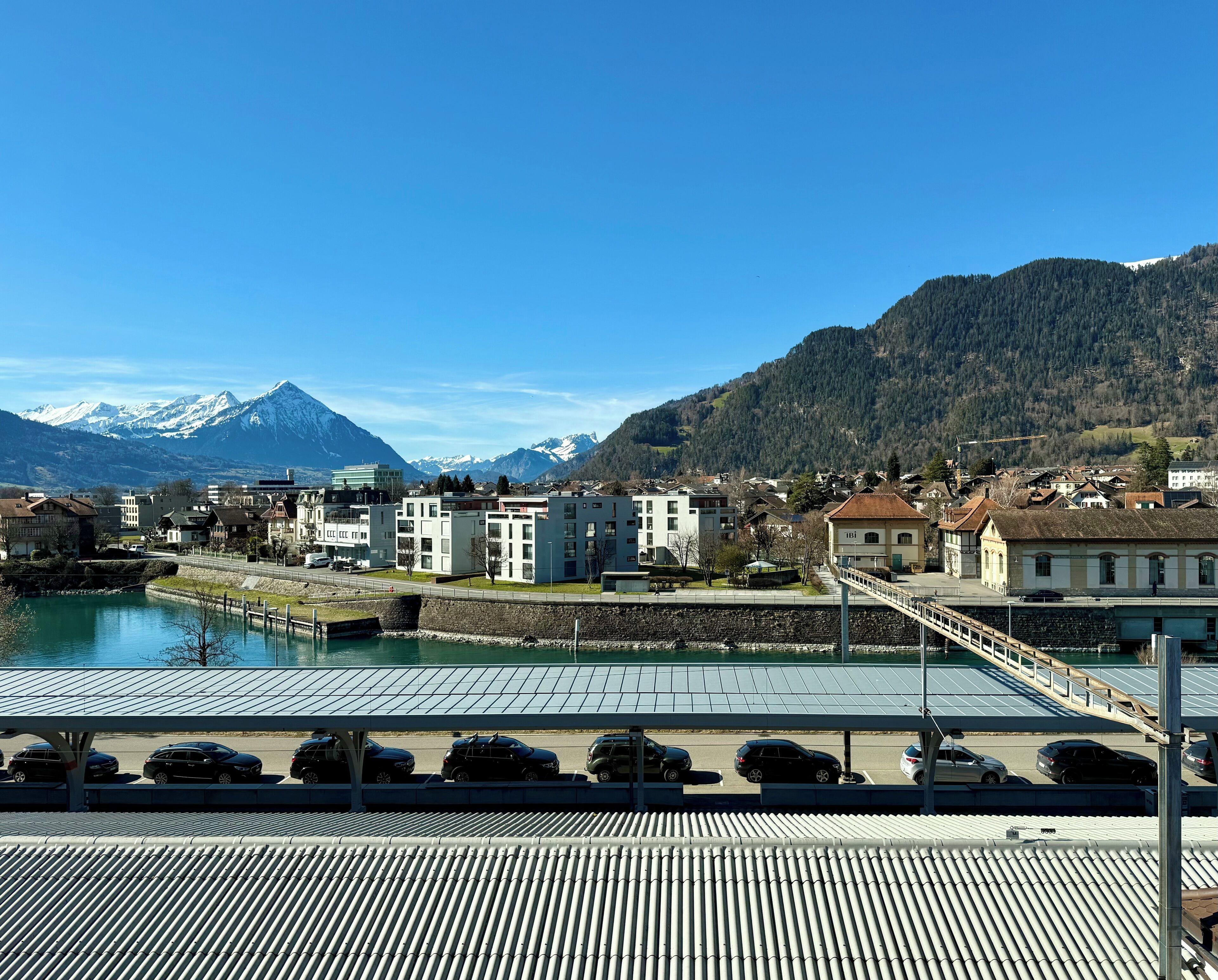 Vista de un pueblo con edificios, un puente y una montaña al fondo.
