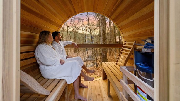 Eine Holzsauna mit Bänken und einem Ofen.