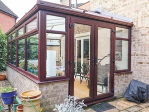A conservatory with a brick exterior, large glass doors, and a wooden roof. - 17 Demesne Gardens (Ipswich)
