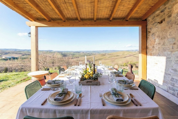 Une table à manger dressée pour deux personnes, avec vue sur la campagne.