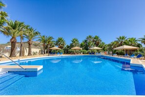 A clear blue pool surrounded by palm trees and lounge chairs. - Ta Frenc Apartments - 2 BDR, 1 BTH (L-Għasri)