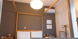 A hotel room with a wooden headboard, a round ceiling light, an air conditioning unit, and two framed pictures on the wall. - ACROPOLITANA 2 (near Acropolis and museum) (Athina)
