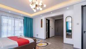 Habitación de hotel moderna con una cama grande, un candelabro, un espejo y vistas a la ciudad.
