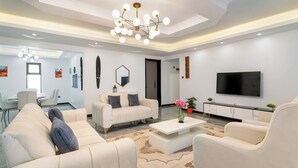 Una sala moderna con un conjunto de sofá, una mesa de centro y un televisor.