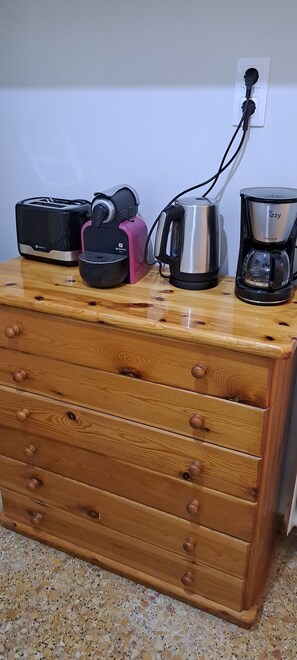 A wooden chest of drawers with kitchen appliances on top, including a toaster, a coffee maker, and a kettle. - The Opera & the Arena 2p apart (Athina)
