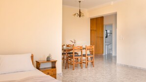 Ein Schlafzimmer mit Bett, Nachttisch und einer Essecke mit Stühlen und Tisch.
