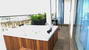 A modern outdoor hot tub area with a wooden deck, a seating bench, and a small table. - Hotel De Alommah Kubwa Abuja Nigeria (Abuja)