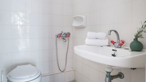 Een badkamer met toilet, wastafel en douche.