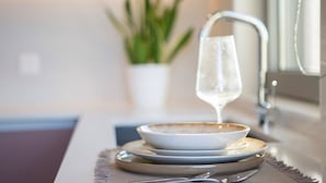 Un comptoir de cuisine avec un verre d’eau, un bol et une assiette.