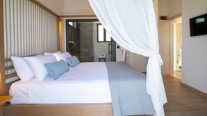 Quarto moderno com uma cama grande, televisão e área de chuveiro em vidro.