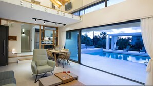 Un intérieur moderne comprenant un coin repas, une piscine et une vue sur l’extérieur.