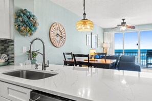 Una cocina moderna con una isla grande, un comedor con vistas y un ventilador de techo.