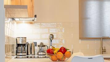 A modern kitchen with wooden cabinets, a white countertop, a sink, and two pendant lights.