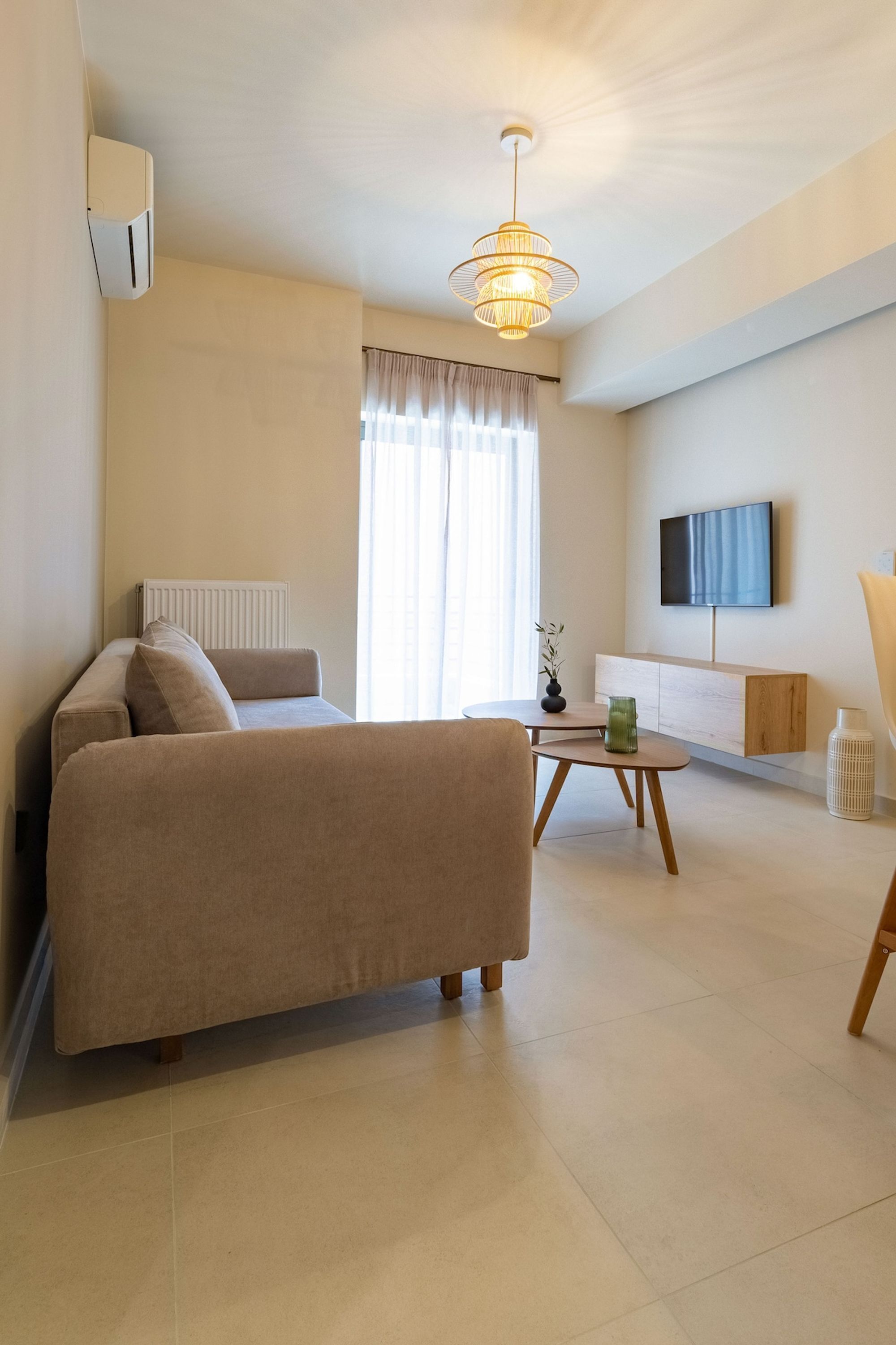 A modern living room with a sofa, a coffee table, a TV, and a radiator.