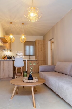 Una cocina moderna con armarios de madera, un comedor con una mesa redonda y un sofá.