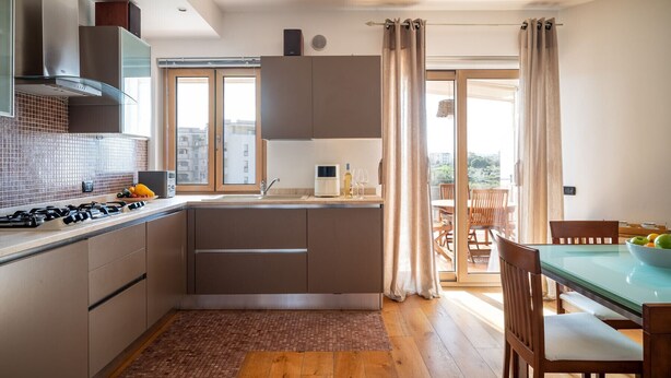 A modern kitchen with a gas stove, a built-in oven, and a large window. - Gimber Lofts 2 by Klodge- vintage flat with Wi-Fi (Olbia)