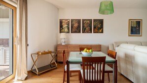 A dining area with a table, chairs, a bowl of fruit, a lamp, and artwork on the wall. - Gimber Lofts 2 by Klodge- vintage flat with Wi-Fi (Olbia)