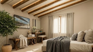 Een slaapkamer met een bed, een bureau, een stoel, een kamerplant en een raam met gordijnen.