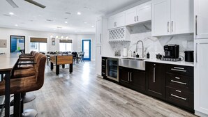 A modern kitchen with white cabinets, a marble backsplash, and a dining area with a pool table. - Stylish 6BR/5BA, DT, Hot Tub, Games, Sleeps 20+ (San Antonio)