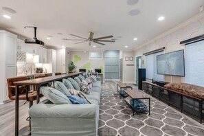 Ein modernes Wohnzimmer mit einer Couch, einem Esstisch und einem Fernseher.