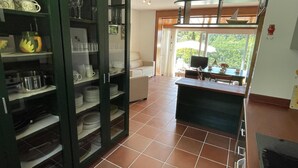 Una cucina con mobiletti integrati, zona pranzo con tavolo e sedie, e vista sull'esterno tramite un'ampia finestra.