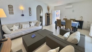 Un salon comprenant un canapé, une table basse et un coin repas avec une table et des chaises.