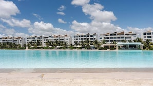 Ein Resort mit großem Pool, mehreren Hotelgebäuden und Palmen.