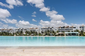 Ein Resort mit großem Pool, mehreren Hotelgebäuden und Palmen.