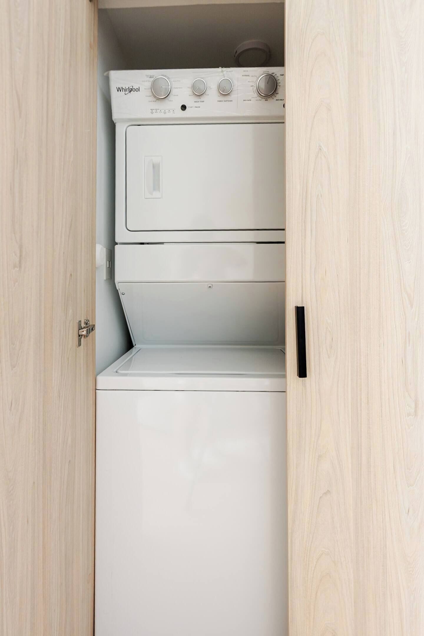 Eine weiße Whirlpool Waschmaschine und Trockner-Kombination in einem Holzkasten.