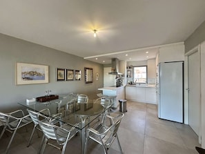 A modern kitchen with white cabinets, a stainless steel refrigerator, and a window. - Sea view apartment, AC - 6 guests (Calvi)
