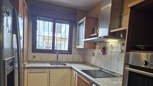 A compact kitchen with a built-in washing machine, a microwave, and a stainless steel refrigerator. - Charming townhouse near river - 6 guests (Denia)