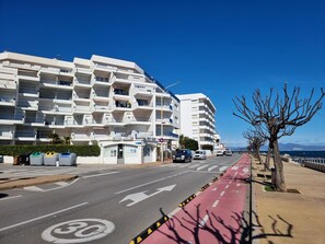 A multi-story building with balconies, a bike lane, and a clear blue sky. - Apartment with sea view - 2 guests (L'Escala)