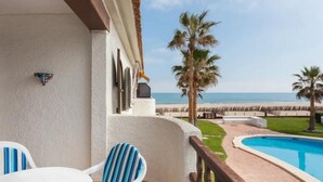 A balcony with a pool, chairs, and a view of the beach. - Apartment with sea view - 4 guests (Denia)
