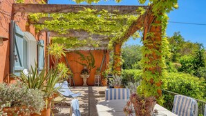 A covered outdoor seating area with potted plants and a table. - Large villa for 2 families - 6 bedrooms - Secure swimming pool - Six-Fours (Six fours les plages)
