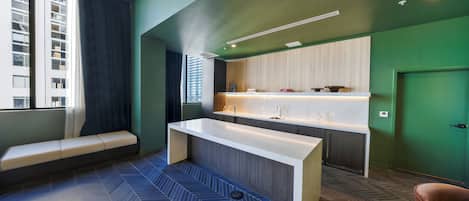 Een moderne badkamer met een grote spiegel, een bankje en een wastafel.