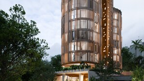 En modern, flervåningsbyggnad med en cylindrisk design, utrustad med balkonger och stora fönster.