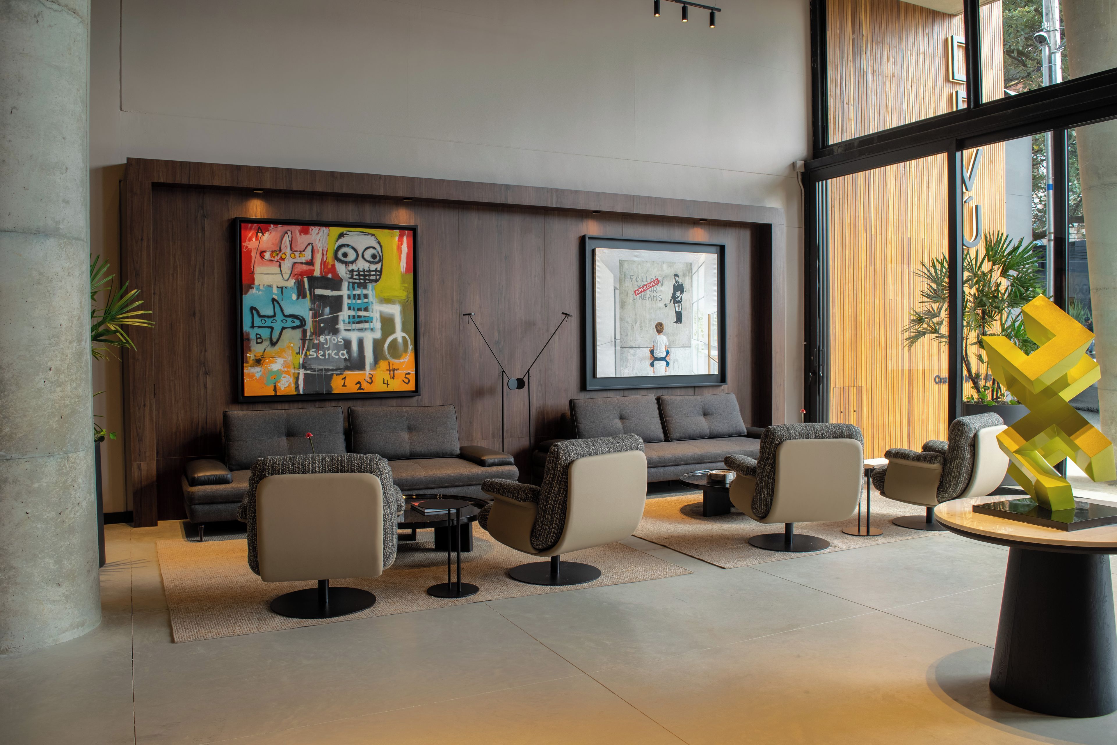 A modern lounge area with sofas, armchairs, and a coffee table.