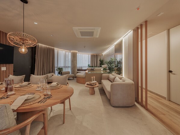 Un salon moderne avec un coin repas, un canapé et une cuisine en arrière-plan.