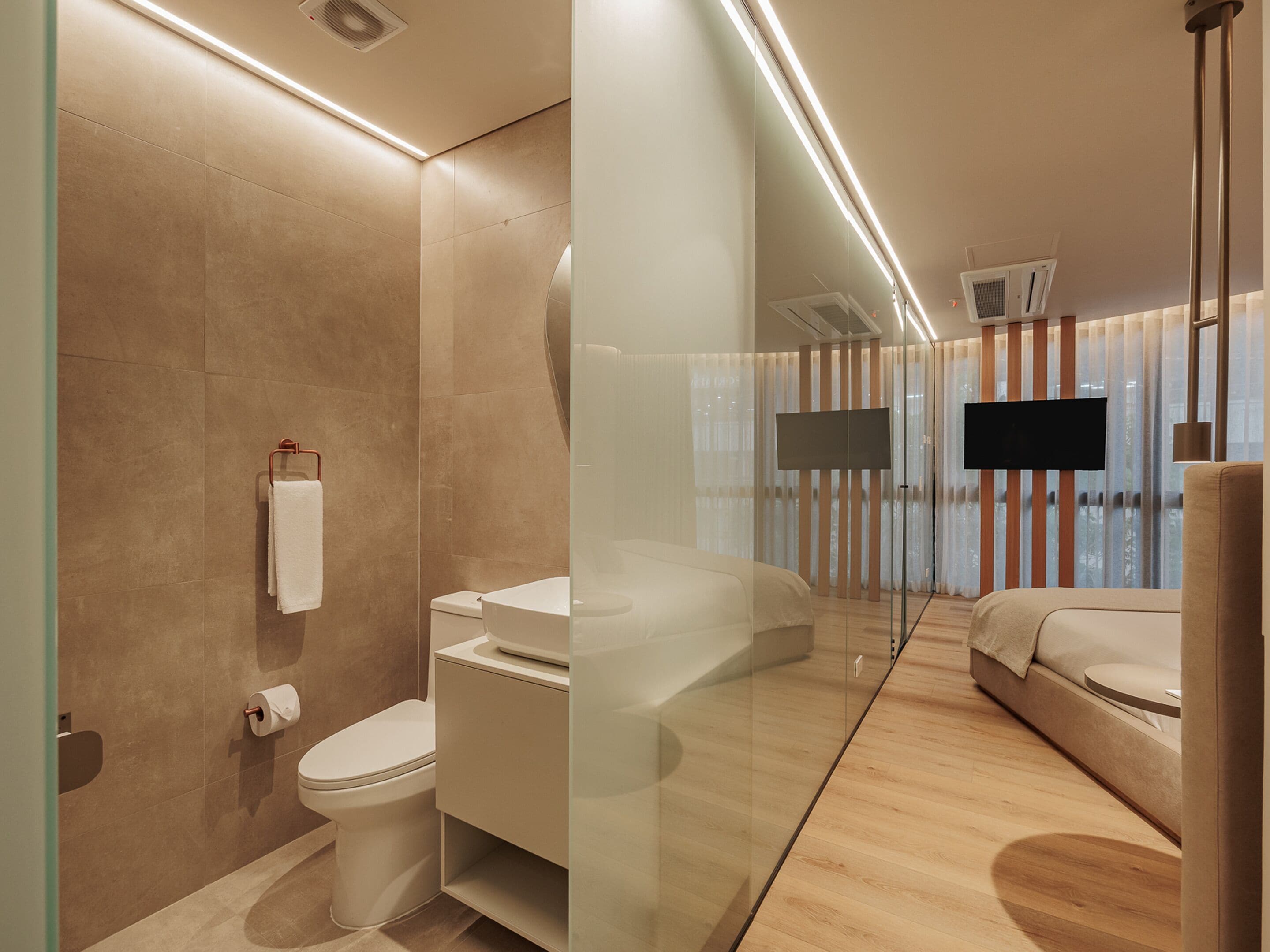 A modern bathroom with a toilet, sink, and glass shower enclosure.