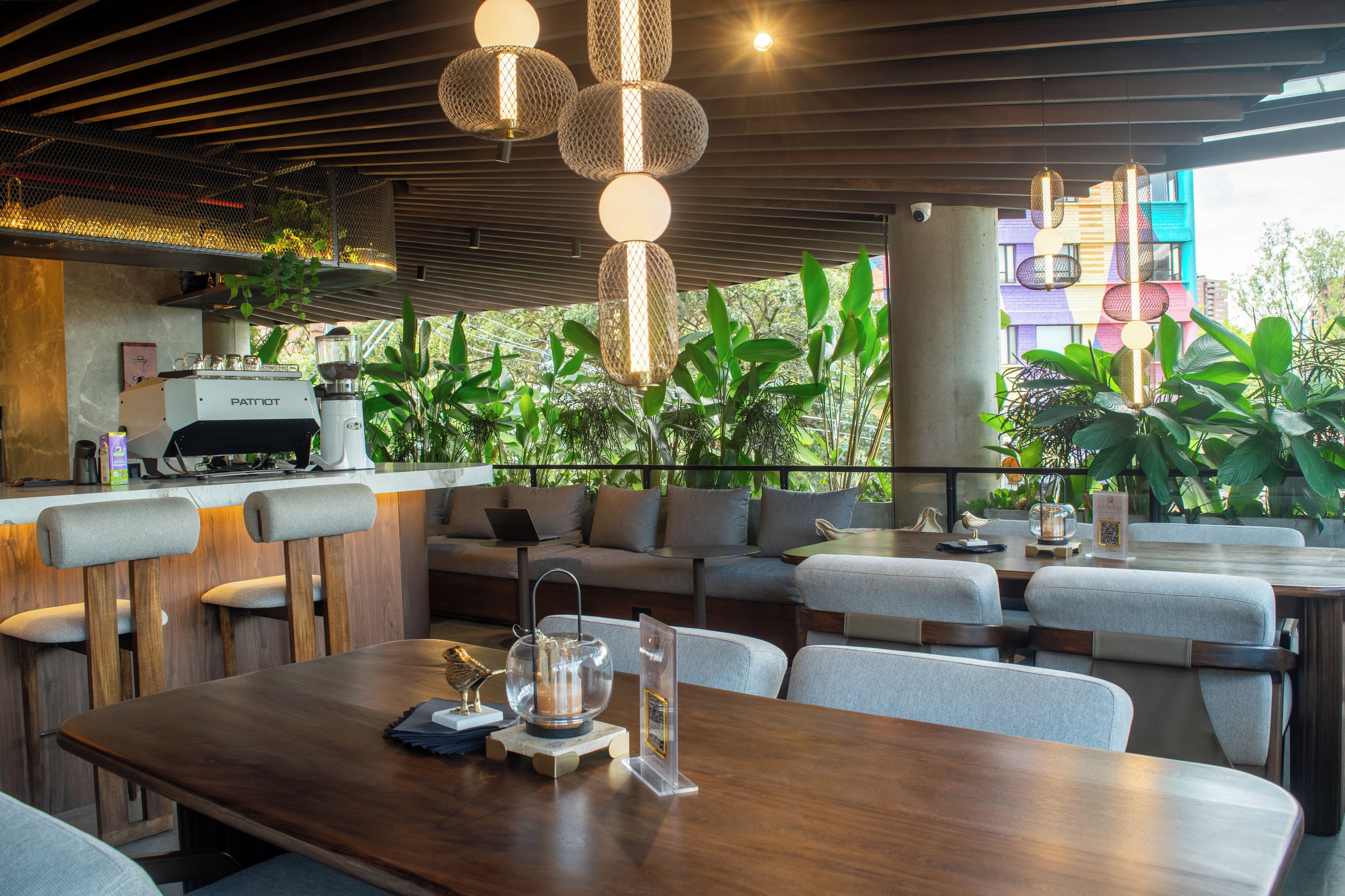 A modern restaurant with a wooden table, bar area, and seating.