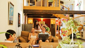 Uma sala de estar ampla com teto alto, escada e varanda.