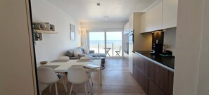 Una cocina moderna con comedor, sofá y vista al mar.