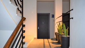 Una scala con ringhiera in legno che conduce a una porta chiusa in alto.