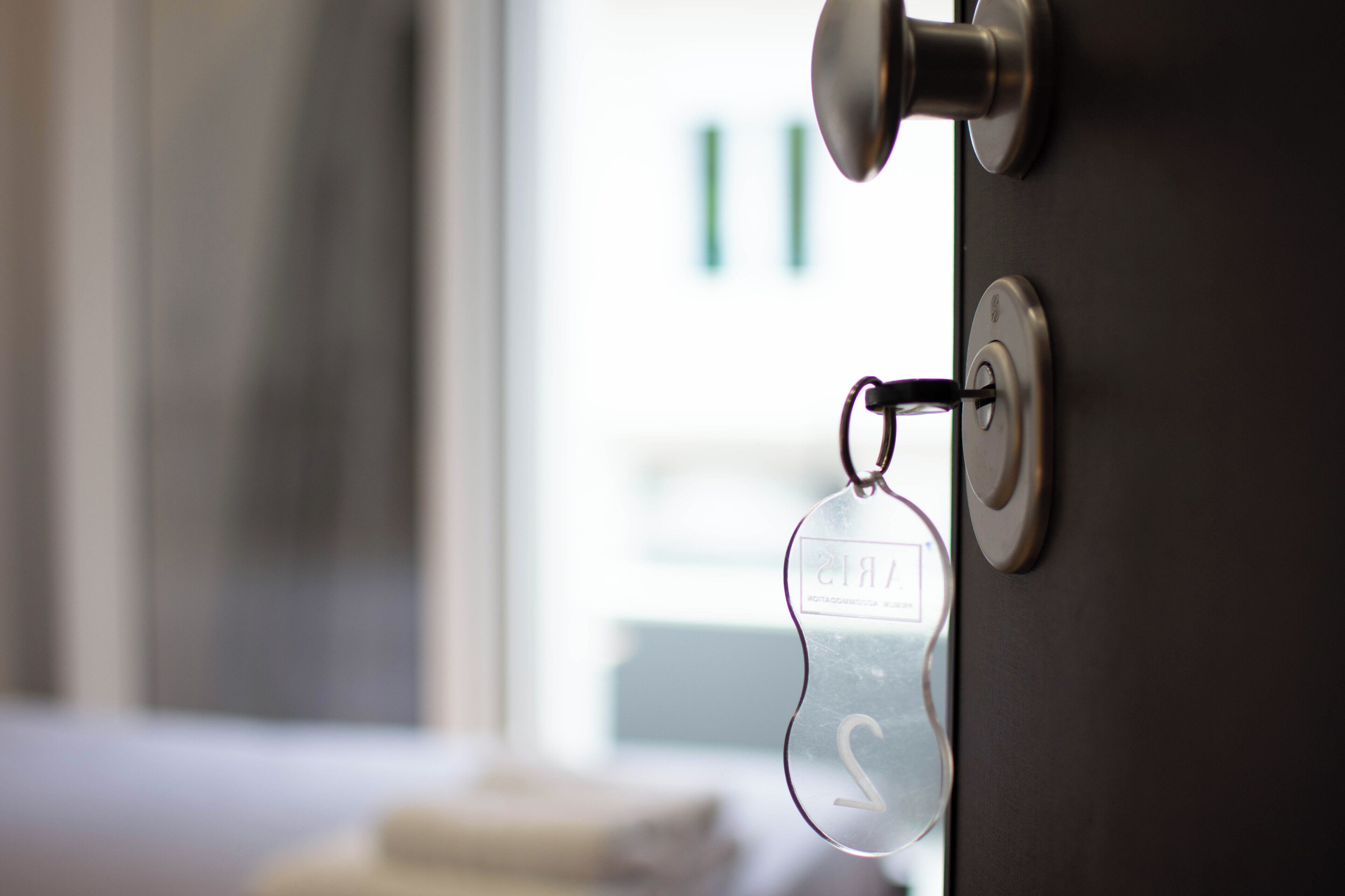 A door with a keyhole and a keychain with a nameplate.