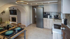 Een moderne keuken met een inbouwoven, magnetron en een koelkast van roestvrij staal.