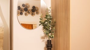 Een houten plank met een spiegel en een potplant.