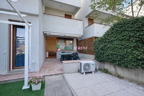 Une maison moderne dotée d’un patio, d’un coin repas et d’un système de climatisation.