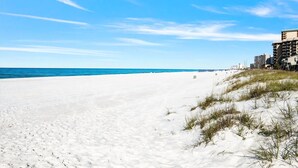 A beach with white sand, clear blue sky, and buildings in the background. - Sand Castle Serenity Studio - Sleeps 4 - Steps to the Beach - No Extra Fees (Panama City)